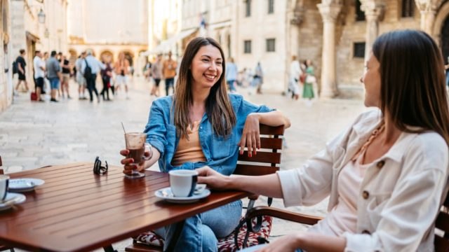 Two women sitting at a street cafe in Europe